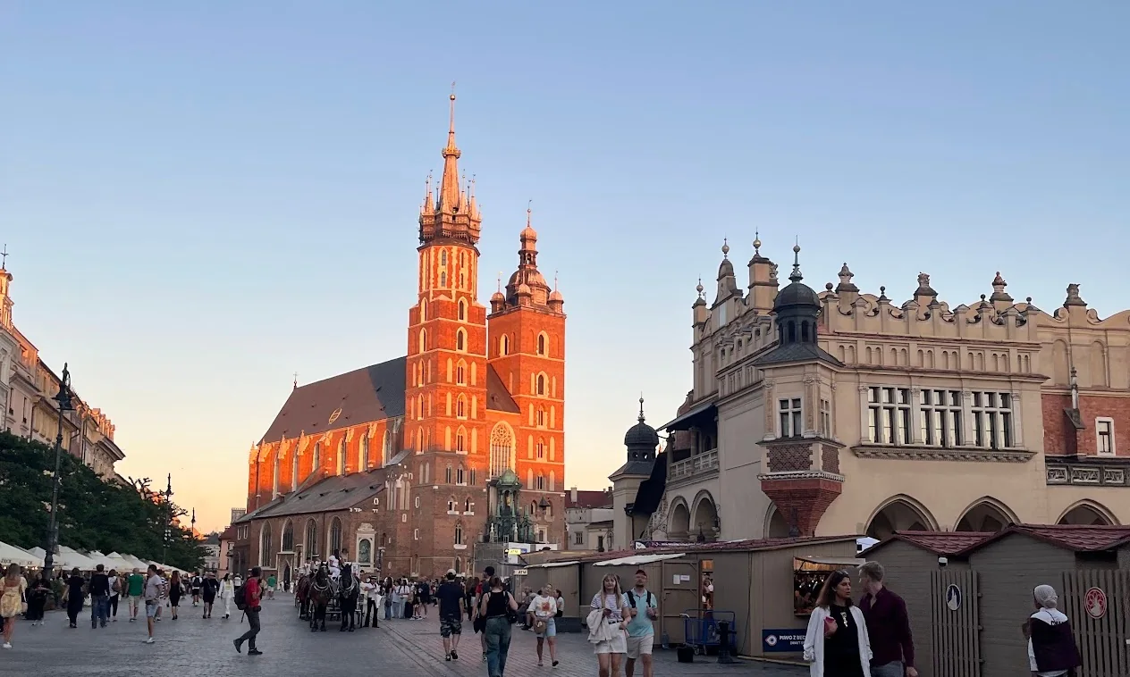 St. Mary's Basilica and the Cloth Hall on Kraków's Main Market Square at sunset.